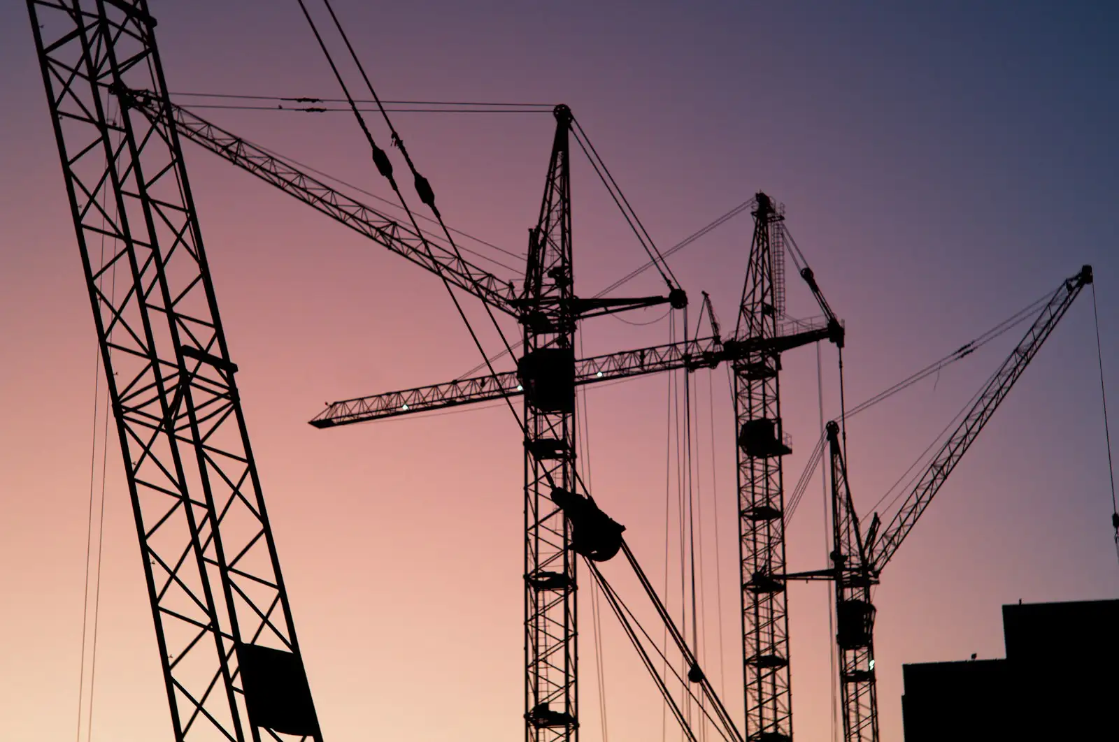 Tower cranes on a construction site at dusk